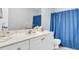 Bright bathroom with a white vanity, matching cabinet, and a blue shower curtain at 190 Crestworth Ct, Powder Springs, GA 30127