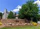 Beautiful home exterior with stone sign, landscaping, and lush green trees at 365 Falling Creek Bnd, Duluth, GA 30097