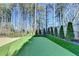 Backyard putting green surrounded by manicured landscaping offers a private space to practice your short game at 365 Falling Creek Bnd, Duluth, GA 30097