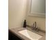 Bathroom vanity featuring a granite countertop, undermount sink, and decorative mirror at 5950 Wintergreen Rd, Norcross, GA 30093