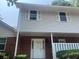 Close view of a two-story townhouse with neutral siding and brick facade at 5950 Wintergreen Rd, Norcross, GA 30093