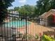 Community pool and building surrounded by a black metal fence and trees at 5950 Wintergreen Rd, Norcross, GA 30093