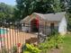 View of pool house with latticework, an umbrella, and poolside landscaping at 5950 Wintergreen Rd, Norcross, GA 30093