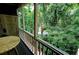 Inviting screened-in porch, with an outdoor view of lush foliage and wood railing at 36 Saint Claire Ne Ln, Atlanta, GA 30324