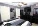 Bedroom with gray walls and a black bed, featuring a ceiling fan and natural light at 704 Olde Mill Ln, Norcross, GA 30093