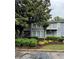 Two-story condo boasts gray siding, balconies, manicured shrubs, and mature trees enhancing curb appeal at 704 Olde Mill Ln, Norcross, GA 30093