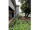 Charming exterior with gray siding, dark door, landscaping and a cozy bench at the entrance, 