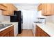 Galley style kitchen with ample counter space, a black refrigerator and white appliances at 704 Olde Mill Ln, Norcross, GA 30093