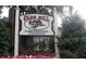 Prominent community sign reads Olde Mill Crossing Condominiums with decorative imagery and manicured flowerbeds at 704 Olde Mill Ln, Norcross, GA 30093