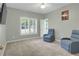 Bright bedroom with carpet, plantation shutters, ceiling fan and two blue chairs at 718 First Cotton Dr, Powder Springs, GA 30127