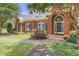 Close up of the front exterior brick home featuring an arched entry, blue shutters, and manicured lawn at 718 First Cotton Dr, Powder Springs, GA 30127
