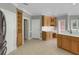 Bright kitchen with wood cabinets, desk area, white countertops, and tile flooring at 718 First Cotton Dr, Powder Springs, GA 30127