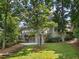 View of the exterior, showing a multi-tiered backyard with deck, patio, and mature trees at 9745 Autry Falls Dr, Alpharetta, GA 30022