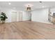 Large finished basement with neutral paint, two doors, wooden light fixture, and light hardwood floors at 9745 Autry Falls Dr, Alpharetta, GA 30022