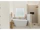 Bright bathroom features a luxurious soaking tub and separate glass enclosed shower at 9745 Autry Falls Dr, Alpharetta, GA 30022