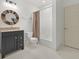Bathroom with a stylish vanity, decorative wood-framed mirror, and a shower-tub combination at 9745 Autry Falls Dr, Alpharetta, GA 30022