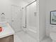 Bathroom with a shower/tub combo featuring decorative tile and white walls, plus modern fixtures at 9745 Autry Falls Dr, Alpharetta, GA 30022
