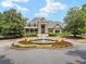View of community clubhouse entrance with fountain and colorful flower bed, and well-manicured greenery at 9745 Autry Falls Dr, Alpharetta, GA 30022