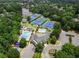 Aerial view showcasing community amenities including pools, tennis courts, and a clubhouse near a lake at 9745 Autry Falls Dr, Alpharetta, GA 30022