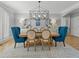 Charming dining room with hardwood floors, wainscoting, stylish lighting, and seating for six at 9745 Autry Falls Dr, Alpharetta, GA 30022