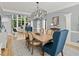 Open-concept dining area with wood table, seating for six and natural light coming from the next room at 9745 Autry Falls Dr, Alpharetta, GA 30022