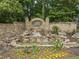 Stone waterfall feature with mature landscaping at the entrance of the Falls of Autry Mill community at 9745 Autry Falls Dr, Alpharetta, GA 30022