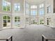 Large event space with gray carpet and view of pool through floor to ceiling windows at 9745 Autry Falls Dr, Alpharetta, GA 30022
