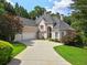 Stately home with a three-car garage and elegant circular driveway surrounded by mature trees and lush landscaping at 9745 Autry Falls Dr, Alpharetta, GA 30022