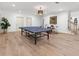 Bright basement featuring a ping pong table, drum set, light fixture, and light hardwood floors at 9745 Autry Falls Dr, Alpharetta, GA 30022
