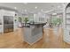A modern kitchen with stainless steel appliances adjoins an open floor plan with a living room and dining area at 9745 Autry Falls Dr, Alpharetta, GA 30022