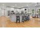 A bright, spacious eat-in kitchen featuring white cabinets, hardwood floors, and a large center island with seating at 9745 Autry Falls Dr, Alpharetta, GA 30022