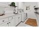 An organized laundry room with white cabinets, shelves, a sink, and a modern washer and dryer at 9745 Autry Falls Dr, Alpharetta, GA 30022