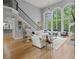 Living room with a staircase, a fireplace, hardwood floors and a wall of windows bringing in plenty of light at 9745 Autry Falls Dr, Alpharetta, GA 30022