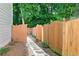 Backyard view displaying a stone pathway lined with wood fencing and lush greenery at 1290 Magnolia Park Cir, Cumming, GA 30040