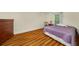 Comfortable bedroom featuring a bed with a lavender quilt, wooden floors, and a dresser at 1290 Magnolia Park Cir, Cumming, GA 30040