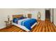 Cozy bedroom with light walls, wood floor, and a comfortable bed; stairs and a hallway are visible at 1290 Magnolia Park Cir, Cumming, GA 30040