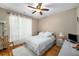 Cozy bedroom with hardwood floors, a ceiling fan, a comfortable bed, and soft, natural light at 1290 Magnolia Park Cir, Cumming, GA 30040