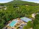 Aerial view of the community pool, clubhouse, and tennis courts surrounded by trees at 1290 Magnolia Park Cir, Cumming, GA 30040