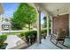 Relax on this covered front porch with a rocking chair overlooking a landscaped yard at 1290 Magnolia Park Cir, Cumming, GA 30040