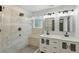 Bathroom features a double vanity, quartz countertops, and tiled shower with bench at 11020 Knotty Pine Pl, Hampton, GA 30228