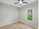 Bedroom featuring wood floors, a ceiling fan and a large window at 11020 Knotty Pine Pl, Hampton, GA 30228