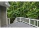 View of the deck showing the gray wood and white railings looking out at the wooded area at 11020 Knotty Pine Pl, Hampton, GA 30228