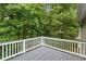 Home deck featuring gray wood and painted white railings overlooking a wooded area at 11020 Knotty Pine Pl, Hampton, GA 30228