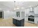 A spacious kitchen with a center island and stainless steel oven with open access to the dining area at 11020 Knotty Pine Pl, Hampton, GA 30228