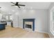 Open-concept living area with hardwood floors, a fireplace, and a view into the modern kitchen at 11020 Knotty Pine Pl, Hampton, GA 30228