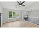 Bright living room featuring wood floors, large windows, a ceiling fan, and an open layout at 11020 Knotty Pine Pl, Hampton, GA 30228
