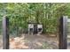 Charming chicken coop nestled within a wooded yard with wire fencing, blending rustic charm with functionality at 1544 Bullard Rd, Powder Springs, GA 30127