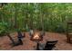 Wooded outdoor fire pit with Adirondack chairs, perfect for cozy evenings under the string lights at 1544 Bullard Rd, Powder Springs, GA 30127