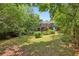A wide angle picture of the green backyard showing the house and stairs to the deck at 1592 Braeburn Se Dr, Atlanta, GA 30316