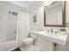 Clean and bright bathroom with a pedestal sink, tub-shower combination, and white tiling at 1592 Braeburn Se Dr, Atlanta, GA 30316